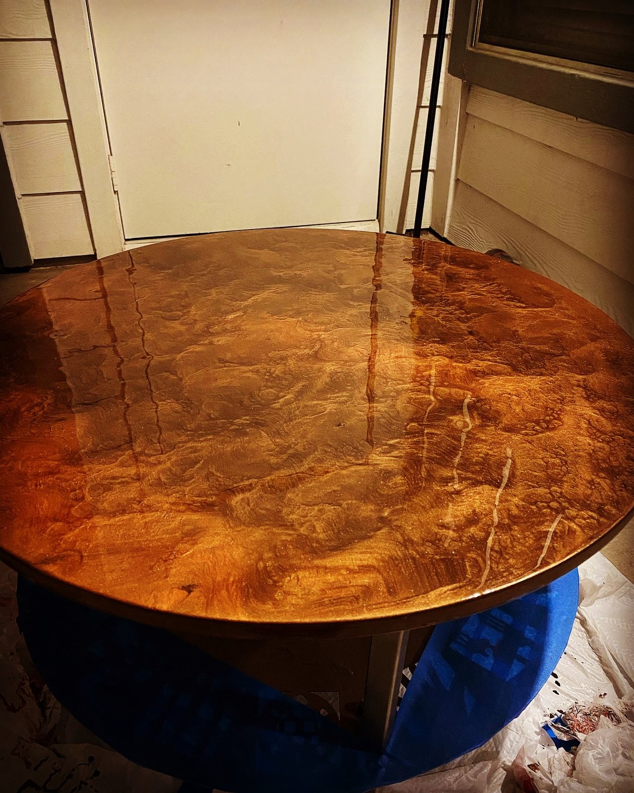 Round tabletop with a glossy copper metallic epoxy finish in Leggari's coffee base with brass highlights, applied with a roller, by HomeWise Services in San Antonio